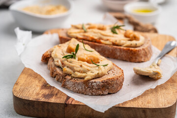 Delicious sandwiches with hummus and ingredients on white table, flat lay. High quality photo
