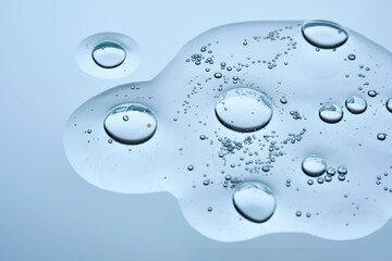 A drop of cosmetic beauty gel texture on a blue background.