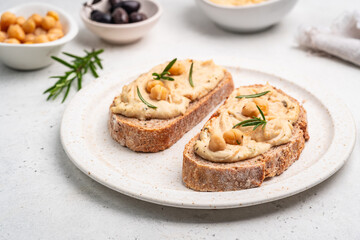 Delicious sandwiches with hummus and ingredients on white table, flat lay. High quality photo