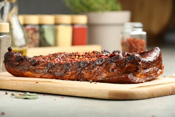 Delicious roasted pork ribs with spices on light table, closeup