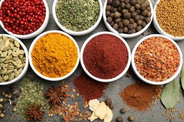 Different aromatic spices on grey table, flat lay