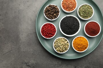 Different aromatic spices on grey table, top view