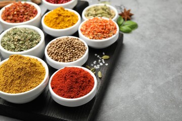 Different aromatic spices on grey table, closeup. Space for text