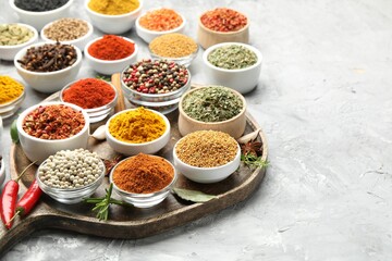 Different aromatic spices in bowls on grey table, closeup. Space for text
