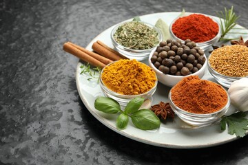 Different aromatic spices on dark table, closeup. Space for text