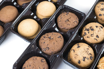Various round cookies in an open box. Cookies in a pack on white