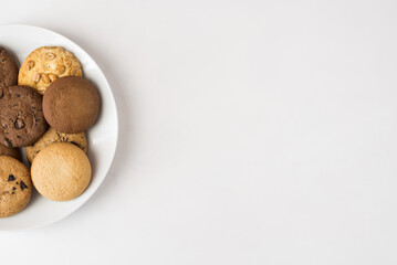 Different round cookies in a white plate on a white background