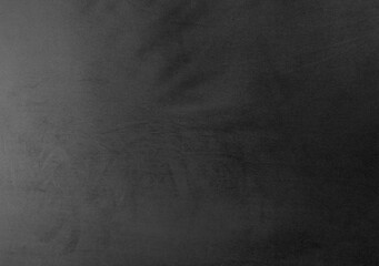 textured surface in varying shades of black, suggesting a soft, possibly velvet-like material with subtle gradients and an overall elegant and luxurious feel, suitable for use as a background.