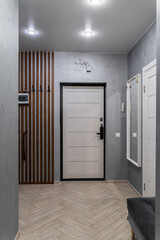 stylish corridor design in flat, apartment, hotel room or house. gray walls. wooden doors, beautiful chandeliers on ceiling. Soft lighting. furniture and entrance hall. large mirror in hallway