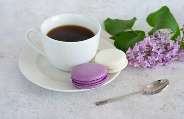 cup of Coffee with purple and white Macarons and branch of lilac Still Life