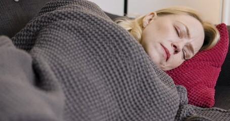Woman, sleeping and relax on sofa in living room in morning at home. Tired person, fatigue and eyes closed head on pillow for weekend afternoon nap, sleep or wellness rest on vacation apartment couch