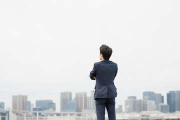 遠くを見つめるビジネスマンの後姿