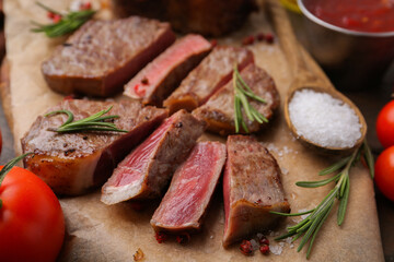 Pieces of delicious beef meat with spices on table, closeup