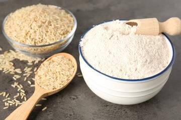 Brown rice and flour on grey table, closeup