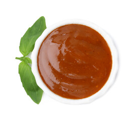Tasty curry sauce and basil leaves isolated on white, top view