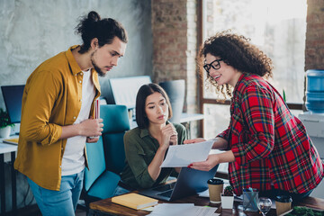 Diverse young professionals collaborating in a casual office setting during a teamwork meeting,...