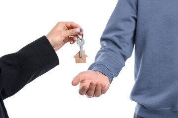 Real estate agent giving house key to new owner on white background, closeup