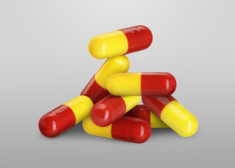 Antibiotic pills. Yellow and red capsules on grey gradient background