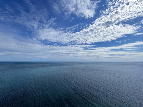 Endless ocean and blue sky clouds.