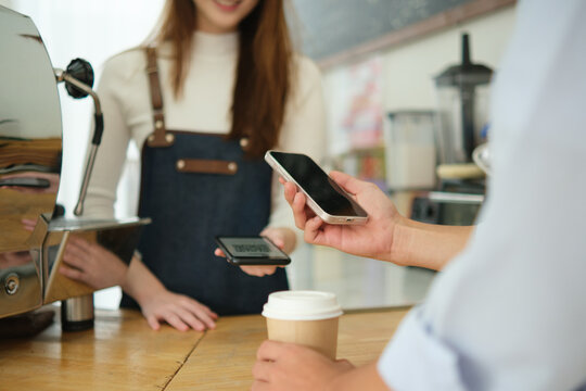 Customer making digital payment at coffee shop using smartphone.