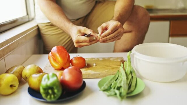 Chef peeling garlic cloves with knife in kitchen