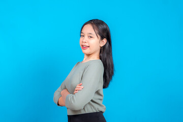 A young woman with crossed arms offers a friendly, slightly coy smile while glancing to the side....