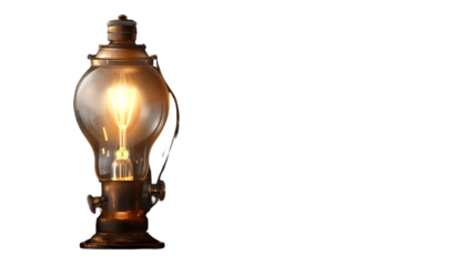 A glowing vintage light bulb with a brass base illuminates against a stark  transparent background creating contrast 