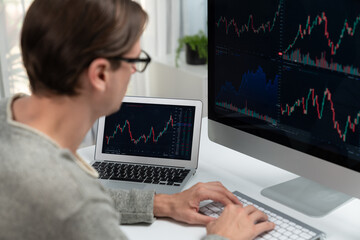 Business trader using computer and laptop to search highest profit value of dynamic increased stock...