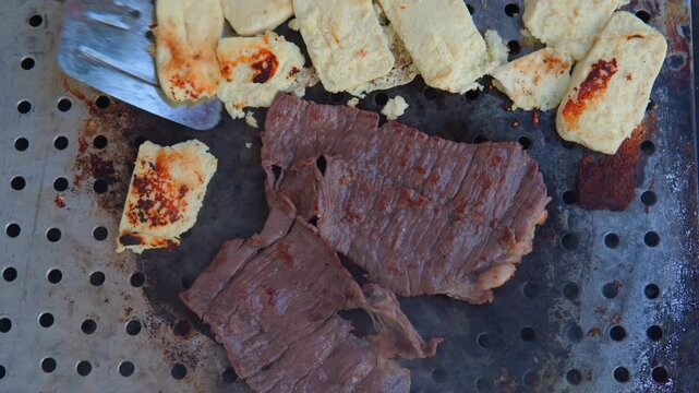 Street cook grilling cecina and queso fresco on comal in mexico