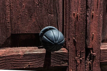 Old rustic wooden door with black knob, Close-up of a weathered wooden door featuring a black round doorknob, textured wood 