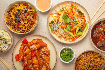 Assorted Chinese dishes, sweet and sour chicken, beef in sauce, noodles, fried rice, salad and wooden chopsticks. Chinese or Asian restaurant concept