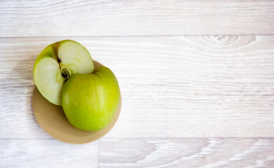 Apples on a light background. A green apple, half or slice of a green apple with the outline of a tenderloin.