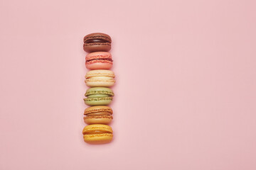 Stack of multicolor biscuits macaron cookies isolated on the bright solid fond plain bright rose...