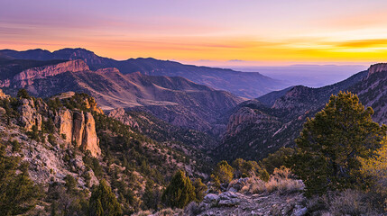 Naklejka premium Panoramic view of mountainous landscape at sunset with vibrant sky and rocky terrain features visible