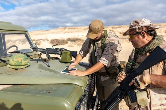 Military soldiers with equipment analyzing strategies outdoors