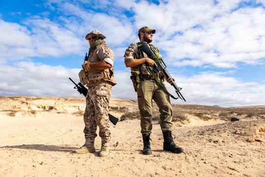 Soldier teamwork in tactical desert exercise under blue sky