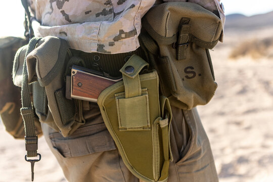 Combat Gear with Holstered Pistol on Desert Surface