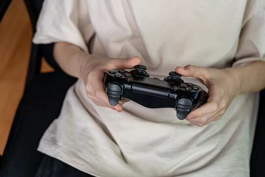 Teenage Gamer Holding Controller Engaged in Video Gameplay