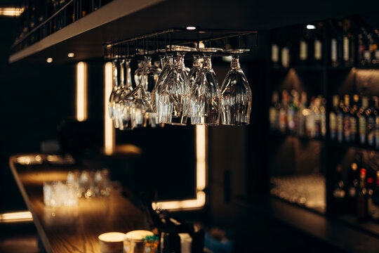 Empty glasses hanging in a stylish dimly lit bar setting
