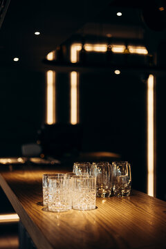 Empty glasses on a wooden bar with warm lighting