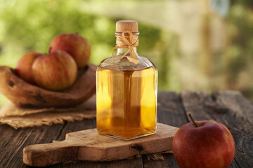 Apple cider vinegar in a bottle with red apples