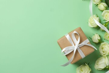 Beautiful white roses with gift box on color background