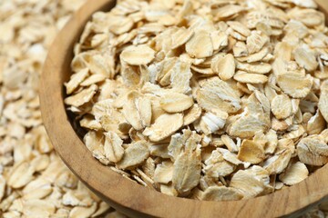 Composition with oatmeal flakes on blue background. Cooking breakfast