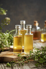 Bottles of herbal tincture made of fresh blooming shepherd's purse plant on a table