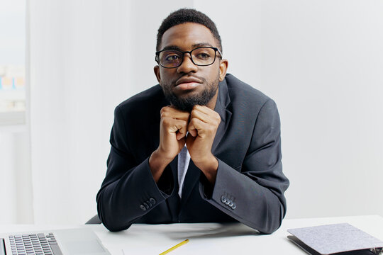 Pensive african american businessman in a suit contemplating at his office desk - Powered by Adobe