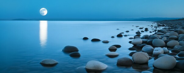 The illuminated moon reflecting upon a calm ocean at twilight