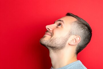 Obraz premium Classy men's short caesar haircut - midlife white man with hair. Red solid background. A man with a stylish hairdo looking confident. Conceptual art of style for aging men.