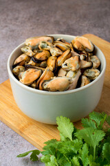 Cleaned boiled mussels in a bowl on a dark background