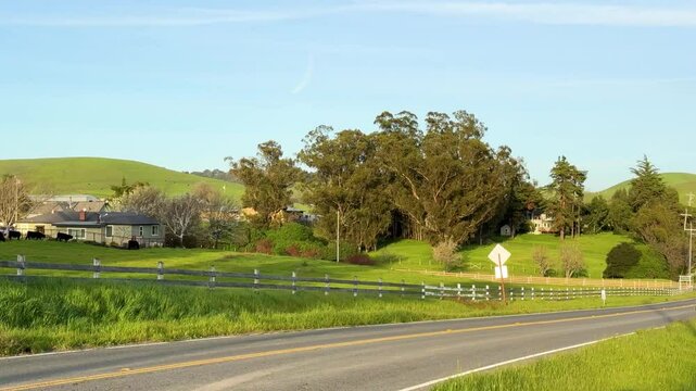 A small rural farming community with barns, homes, and fields under bright blue skies, capturing agricultural life.