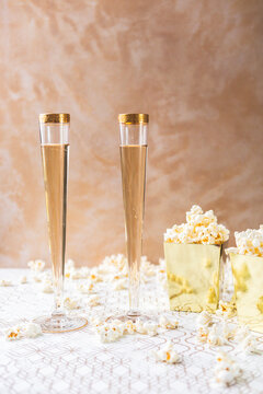 Two Champagne Flutes with Gold Rims with Popcorn in Gold Containers